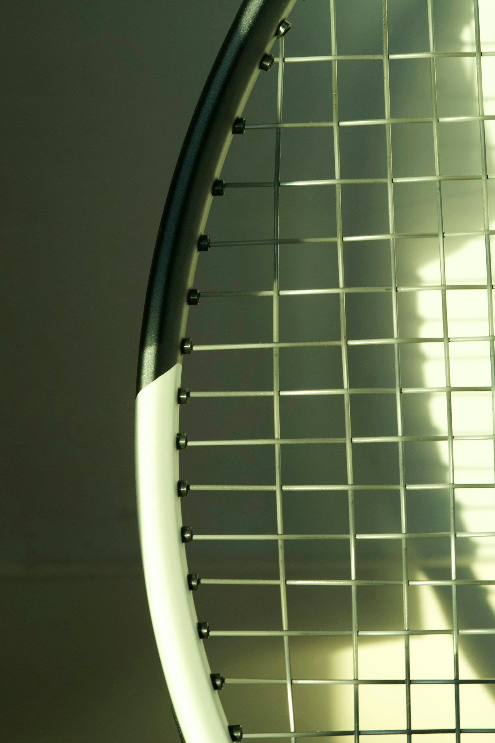 Close-up of a tennis racquet frame and woven strings.